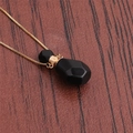 Macro detail of faceted black stone perfume bottle pendant on brown leather texture - NSN0231 Black Stone