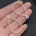 Two silver teardrop-shaped alloy earring frame pendants held on a palm for size reference - Water Drop Bezel (22248) / 38x21mm / Bright Silver