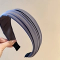 Vue détaillée du serre-tête en tissu plissé bleu foncé montrant sa texture soyeuse - Gris