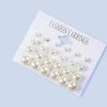 Detail view of 12 pairs of minimalist white pearl earrings in various sizes on a card - 12 Pairs Set / Beige