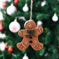 Detailed view of gingerbread man ornament with green bow tie on a Christmas tree - Green Bow Style