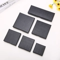 Set of six black textured paper jewelry boxes in various sizes on a white background - Black