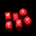 Set of six glowing red LED ice cubes with water sensor feature in a dark background - Red