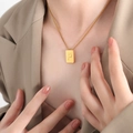 Square gold pendant necklace with embossed letter P on a fine chain worn by a model - Letter P Style (P1506-P)