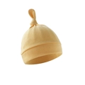 Detail showing soft light yellow cotton knit baby hat with top knot on white background - Ginger Yellow