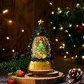 Detail of a glowing Christmas tree lantern with a snow globe scene and golden base decor - Green Christmas Tree Style