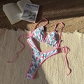 Two-piece floral bikini set with triangle tie top and high cut bottoms on resort rug - Pink Floral