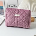 Pink corduroy quilted makeup bag with zipper closure on desk with cozy lamp and laptop - Purple