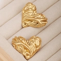 Détails macro des boucles d'oreilles cœur dorées avec finition texture lave et nervures - Boucles d'oreilles cœur texturées irrégulières