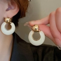 French luxury gold hoop earrings with white resin rings worn by a model in soft light - Gold/White Spherical Hoop