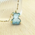 Detail of light blue resin bear pendant with gold starfish charms on a gold chain - Pale Blue Lip Chain