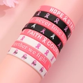 Silicone awareness wristbands with pink ribbon motifs and motivational slogans on stand - Pink Series Style