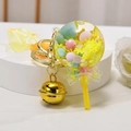 Lollipop keychain with yellow fluid sand and gold bell on a white display stand - Snowflake Lollipop [Lemon Yellow]