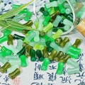 Bamboo-shaped glass beads in various green shades spilling from a transparent bottle - Bamboo Style (J22#)