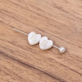 Detail of heart shell pendant with gold letter E and pearl on minimalist metal pin - Letter E
