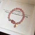 Detailed macro view of strawberry quartz beads and a carved pixiu charm on the bracelet - 29# Lucky Pixiu Strawberry Quartz Bracelet - Gift Box