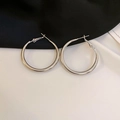 Detailed close-up of polished silver hoop earrings with a vintage lace-inspired design - Silver Needle Silver Medium