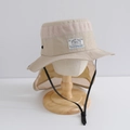 Dettaglio dei fori in rete e del sottogola regolabile su un cappello beige con paranuca - 55cm circa 6-12 anni / Beige