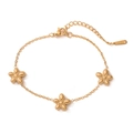 Dettaglio della collana con pendente a fiore dorato con tre charms e chiusura a moschettone - Bracciale quadrifoglio / Oro