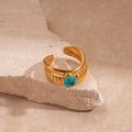 Detailed close-up of double-layered gold ring with blue zircon stone on stone base - Gold Double Layer