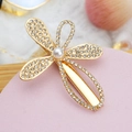Close-up of golden hair clip with shimmering rhinestones and a central pearl detail - Style 05-Clover Shape