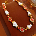 Detail showing vintage flower metal texture with red gemstone and baroque pearl - Necklace - Gold - Pink