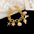 Gold ocean themed charm bracelet with starfish and shell pendants on a thick link chain - Gold Ocean Element Bracelet