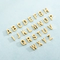 Set of 26 golden stainless steel letter pendants A-Z arranged on a blue textured background - 3d Version - Gold / Letter Y