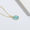 Elegant gold necklace with oval seahorse pendant on blue background on white surface - Blue Seahorse