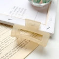Pince à cheveux rectangulaire ajourée beige minimaliste sur fond de livre vintage - Blanc Crème Gelée