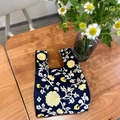 Knitted tote bag with yellow floral pattern on deep blue base in a classic handheld style - Black Hydrangea