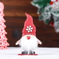Detailed view of a handmade wooden Christmas gnome with white fur beard - Standing Snowflake Style / Red Hat Rudolph