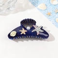 Dettaglio del mollettone a conchiglia blu glitterata con perle e strass a forma di stella - 10.5cm / Blu Stellato