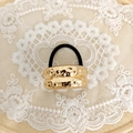 Detail of a minimalist gold hammered metal hair tie with high-elastic black rubber band - Gold Double Bar Liquid Metal