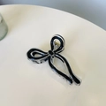 Macro detail of acrylic ribbon claw clip with black outlines and golden spring - Approx. 9.5cm / Black
