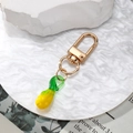 Minimalist keychain with artistic yellow and green glass fruit pendant on golden hook - Yellow Eggplant