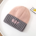 Detailed top view of a color-block knitted hat with pink N.O.T embroidery on white tray - Hat Only / Pink
