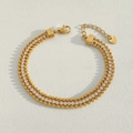 Détail d'un bracelet triple couche en perles dorées avec zircons et étiquette S.steel - Style Perle CZ à Trois Couches (K539) / Doré