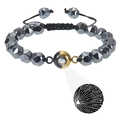 Macro detail of faceted tiger eye beads and projection stone on adjustable woven bracelet - Hematite