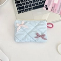 Flat lay of a light blue quilted cosmetic bag with decorative bows on a white desk - Light Blue Plaid