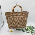 Detail of woven straw tote bag with natural bamboo handle and brown leather accents - Large / Wave Texture