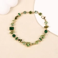 Elegante bracciale dorato con zirconi verdi geometrici su supporto in pietra chiara - Bracciale