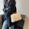 Chic cream white crossbody bag with metal buckle shown on model in a stylish pose - Off White