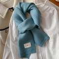 Detail showing foggy blue knitted scarf texture with emo label on beige jacket - Haze Blue