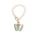 Golden butterfly pendant with light green pearlescent wings and crystal accents on chain - Green