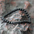 Black agate beads bracelet for men with silver metal spacer discs on grey rock - Polished Stone + Hematite