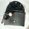 Detailansicht der schwarzen Stroh-Umschlagtasche mit Pompons und magnetischem Verschluss - Schwarz