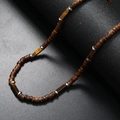 Men's coconut shell beaded necklace featuring a brown tiger eye stone on black background - Tiger Eye