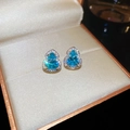 Detailed macro view of gold-plated gourd stud earrings with vibrant blue cubic zirconia - Gold-Blue