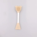 Detailed view of beige dual-sided silicone face brush with bear-shaped head and spatula - Yellow